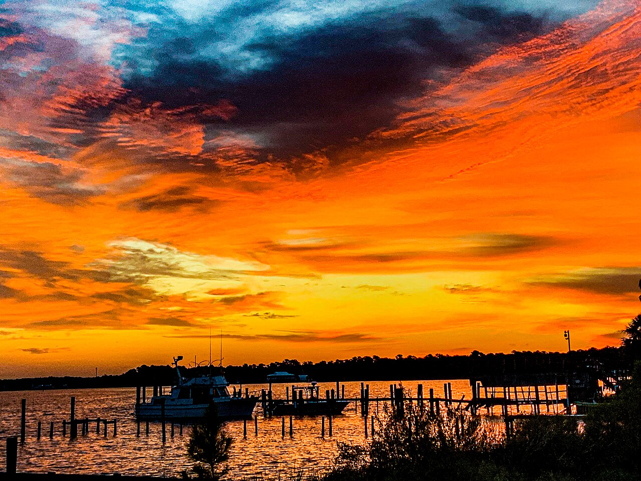 Boats at a marina under a fiery Gulf Coast sunset